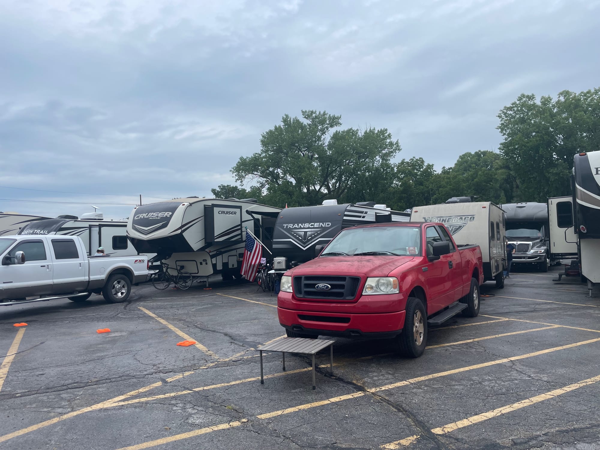 Truck and travel trailer parked with others in a parking lot.