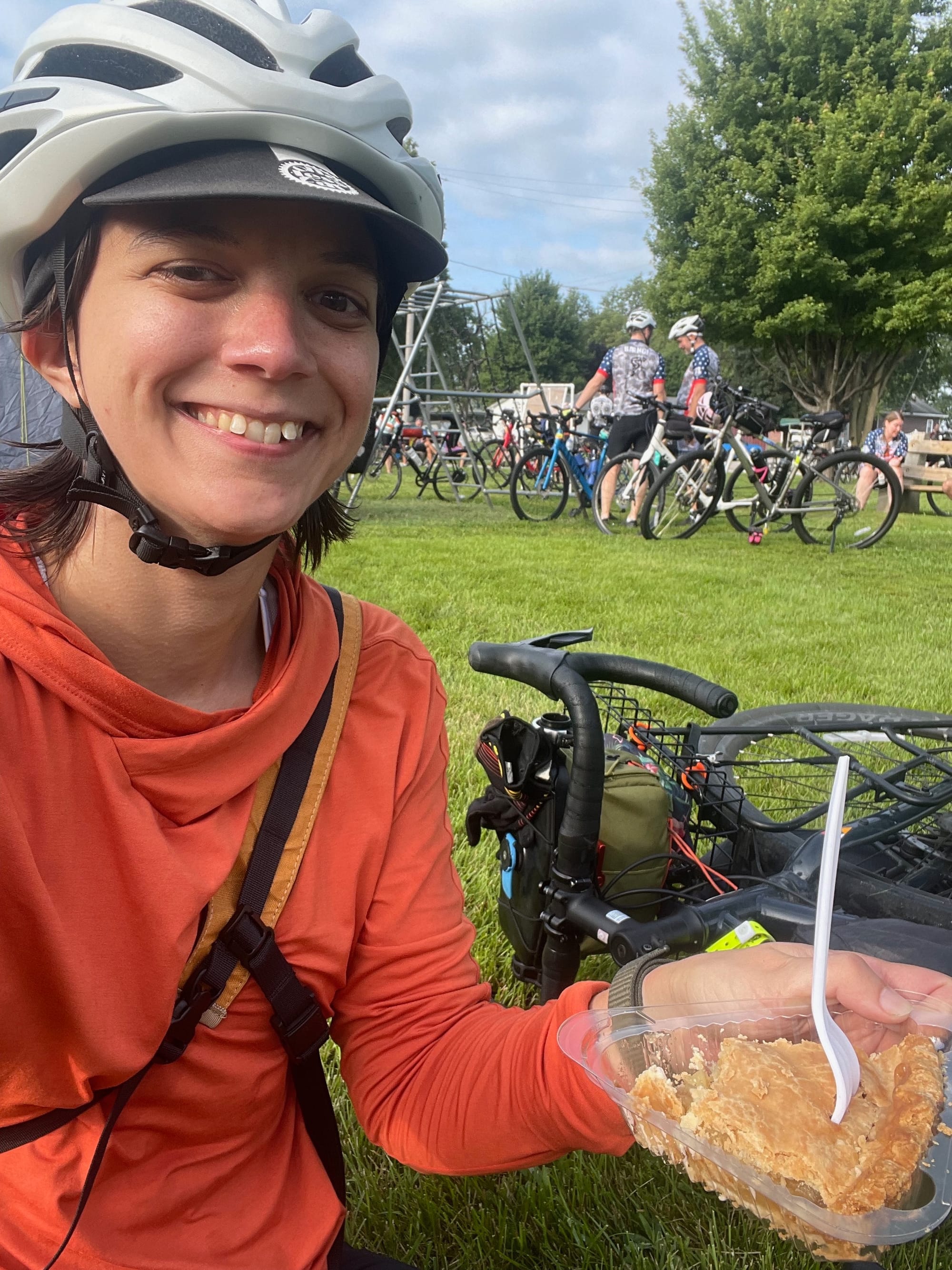 Me holding a slice of pie with lots of bicycles in the background.