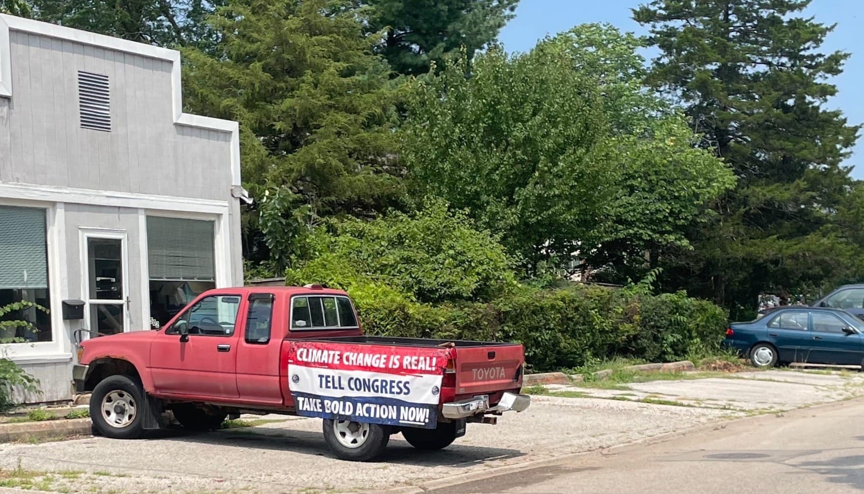 Parked pickup truck with a banner that says "Climate change is real! Tell congress. Take bold action NOW!"