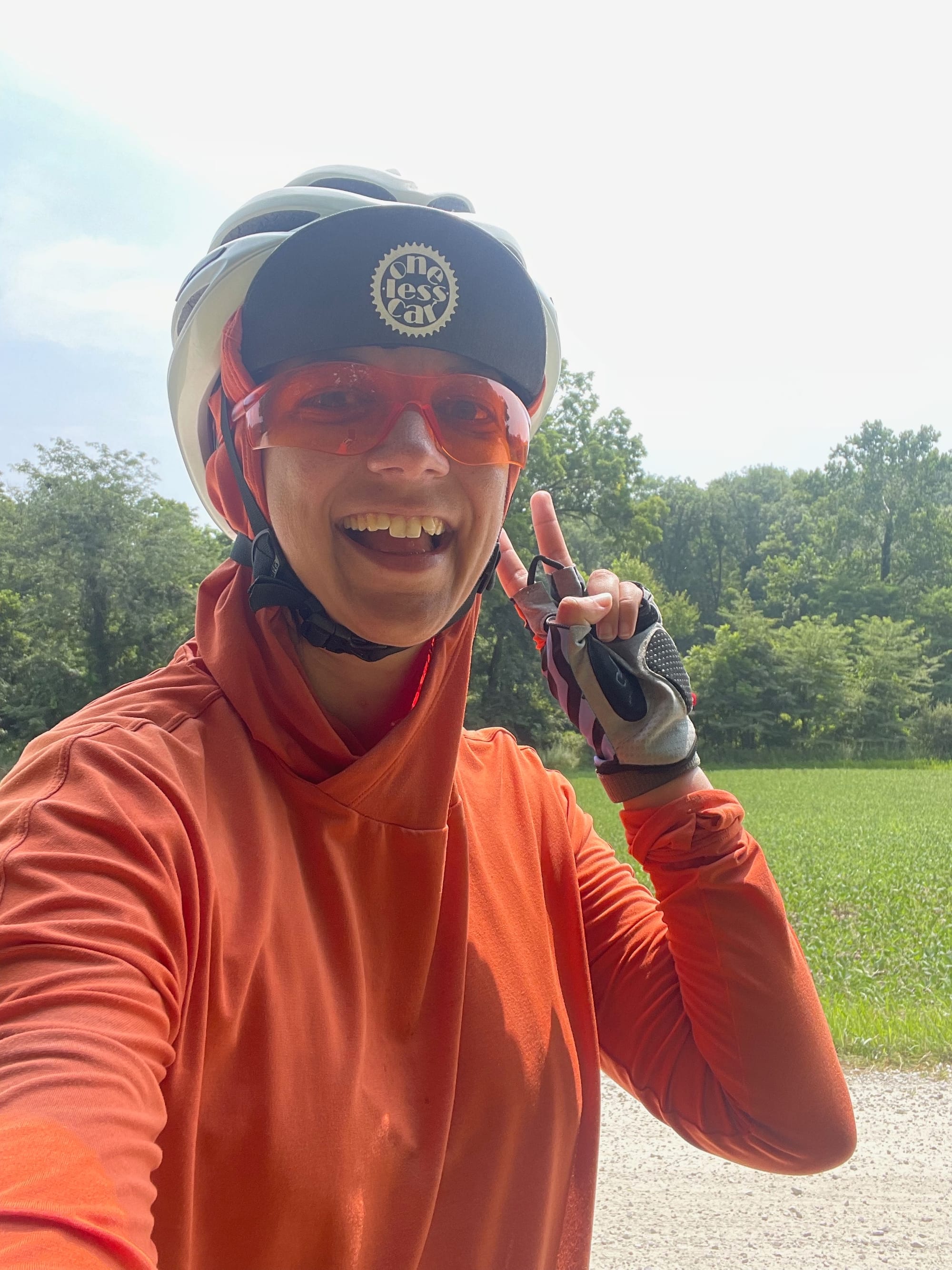 Me in all my biking gear throwing a peace sign on a gravel road.