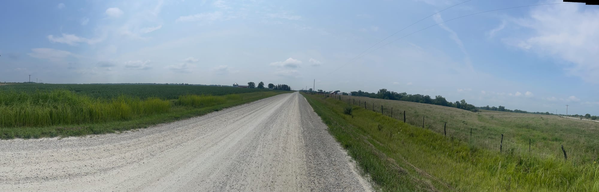 Grassy plains and gravel road panorama.